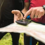Hiker using AI travel app in mountains 2025